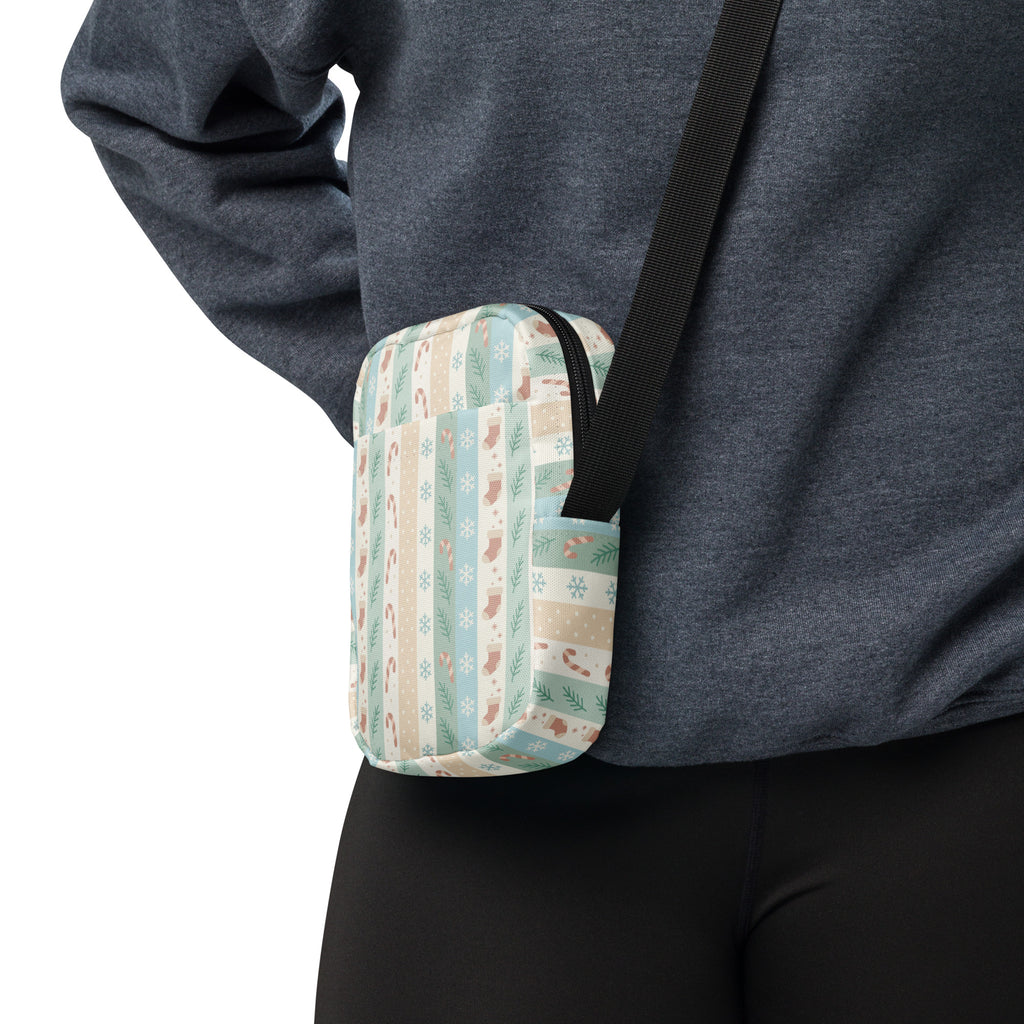 A cozy rectangular crossbody bag in pastel stripes with holiday motifs on soft fabric for festive use