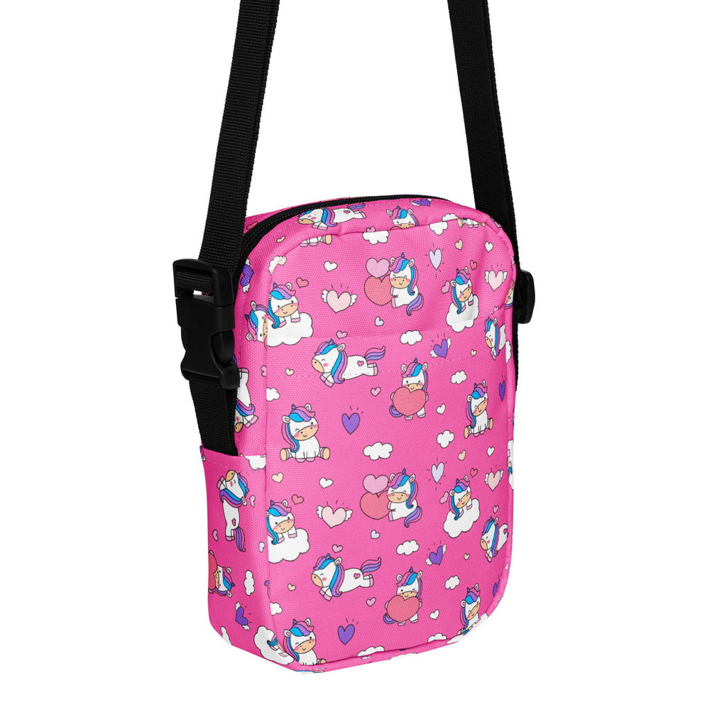 Girls pink crossbody purse featuring unicorn patterns with black adjustable strap for easy carrying