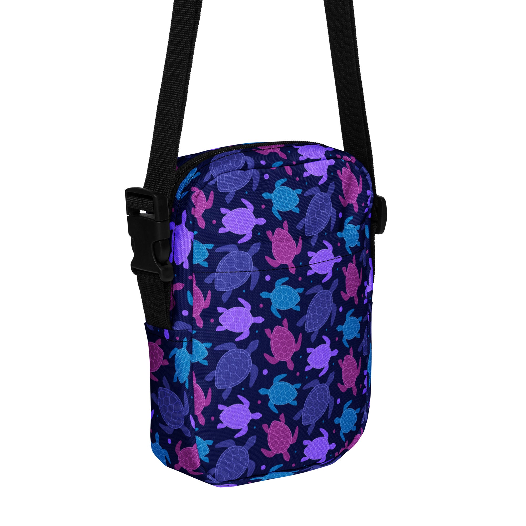 A navy blue girls crossbody purse with vibrant purple pink and teal sea turtle patterns