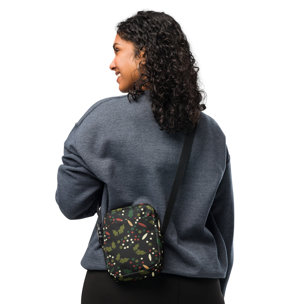 Black crossbody bag with red christmas holly berries festive pattern of green leaves and white lights