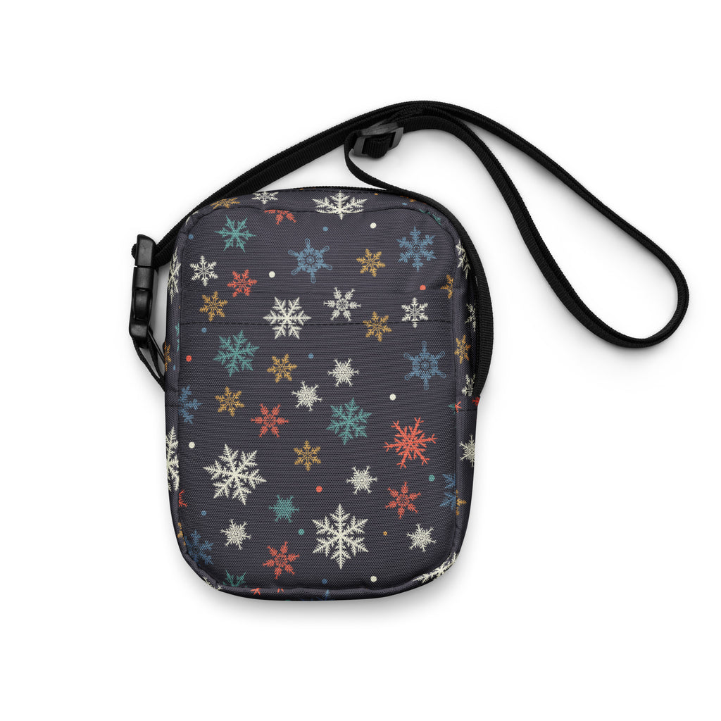 A dark gray crossbody bag with vibrant white red blue and gold snowflake patterns for women