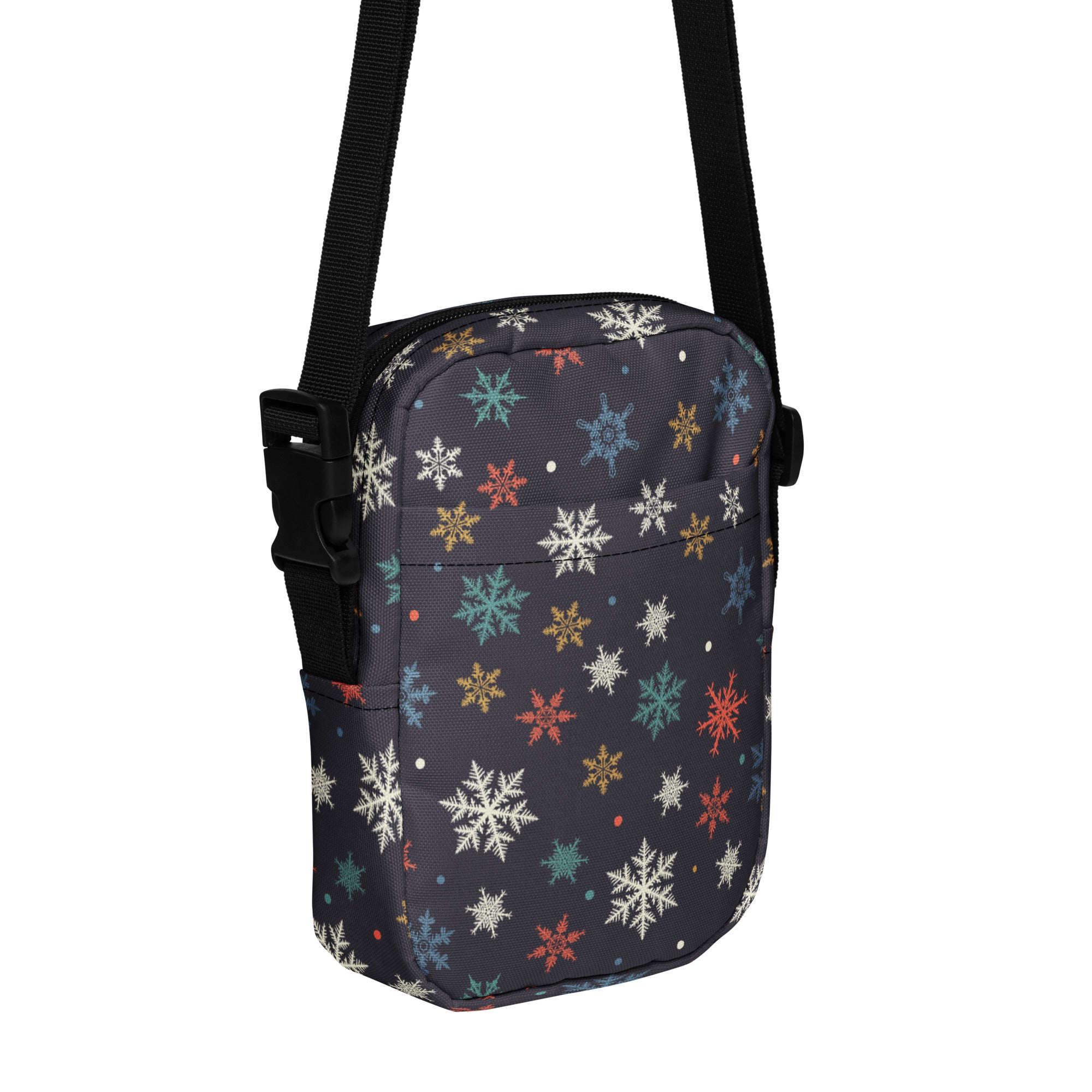 A dark gray crossbody purse with a colorful snowflake pattern in white teal gold and red for women