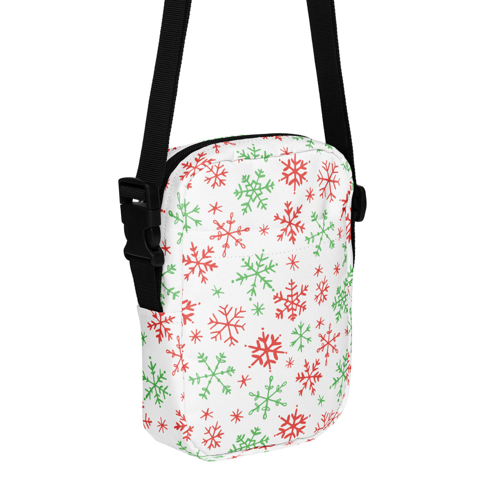 White crossbody bag with red and green snowflake pattern and black adjustable straps for christmas use