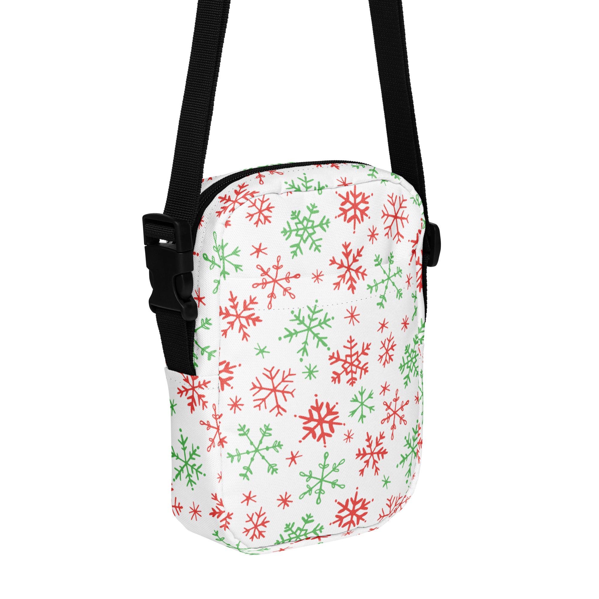 White crossbody bag with red and green snowflake pattern and black adjustable straps for christmas use