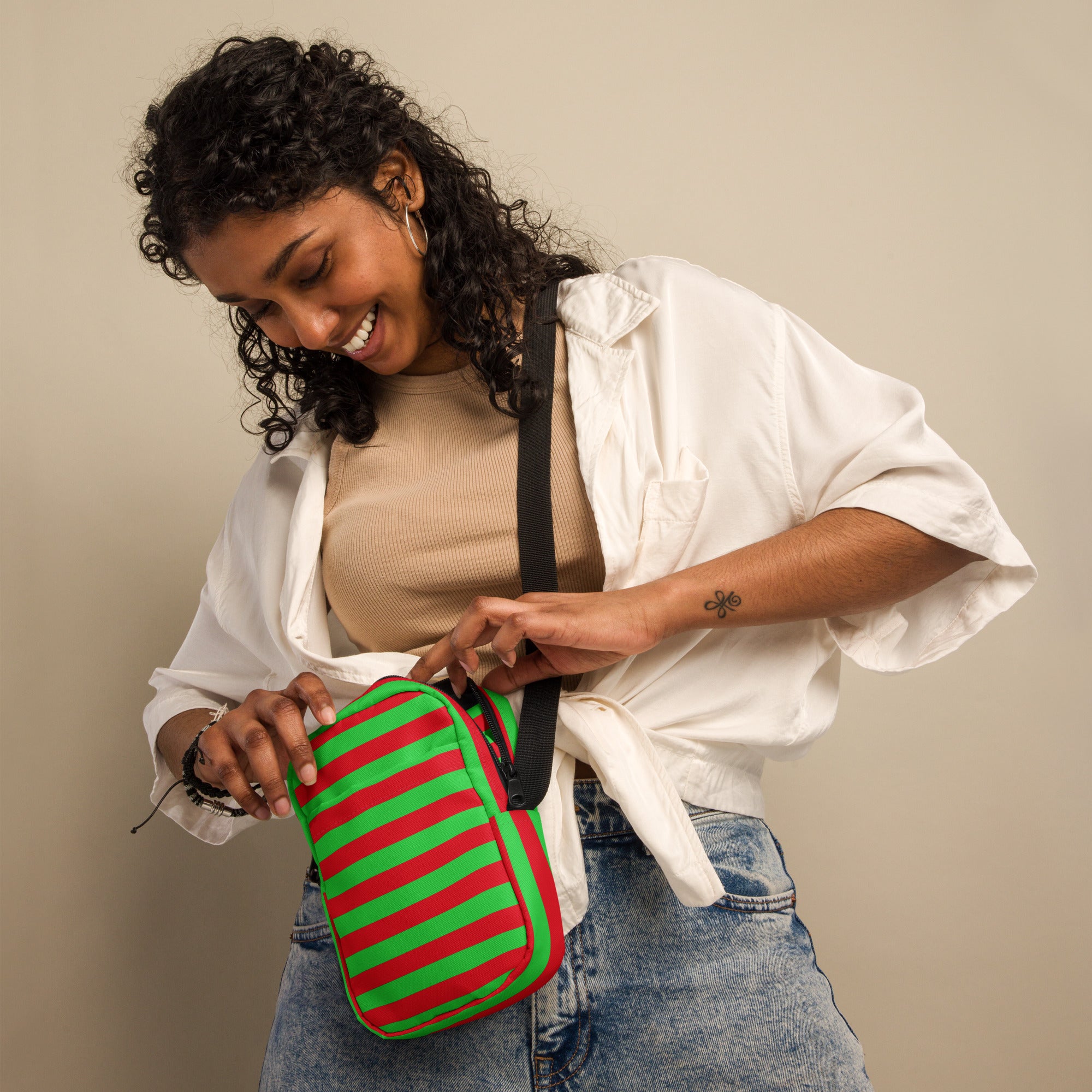 A vibrant green and red striped leather crossbody purse with a black strap for women during Christmas