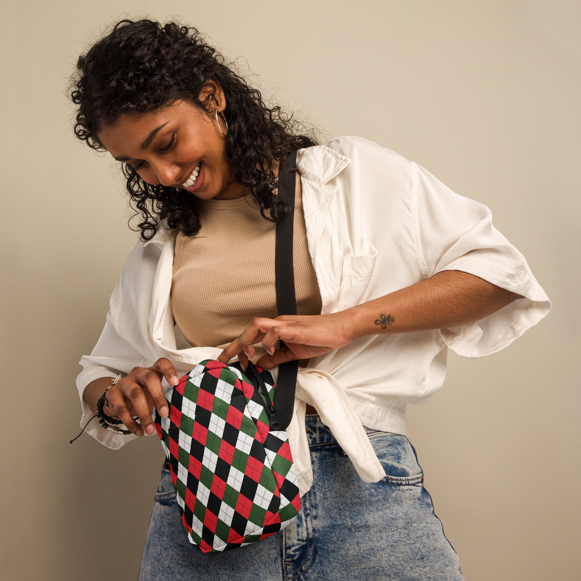 A compact red and green argyle-patterned crossbody purse with a black strap for women’s Christmas style