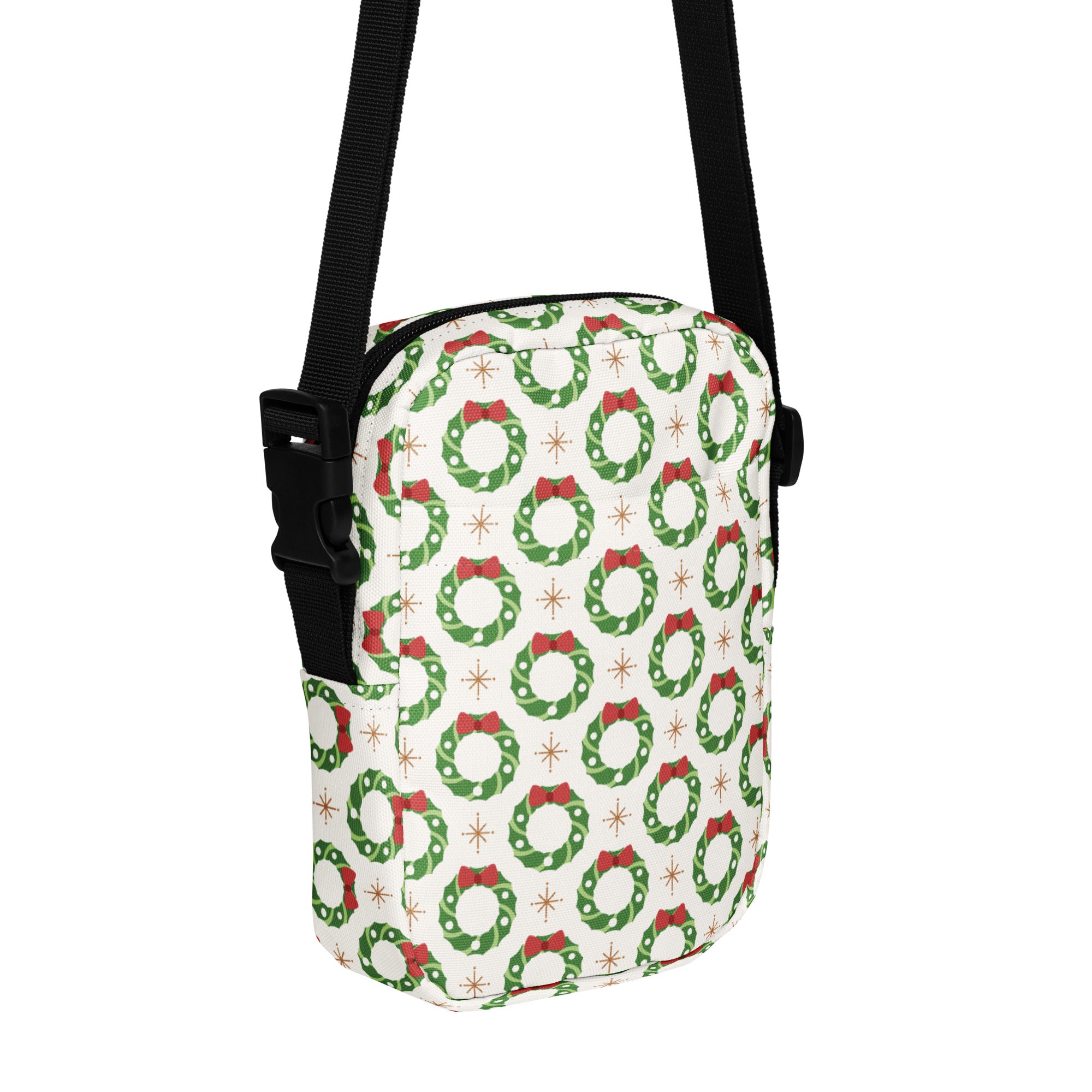 White crossbody bag with green wreaths red bows gold starbursts and black adjustable strap Christmas wreath design