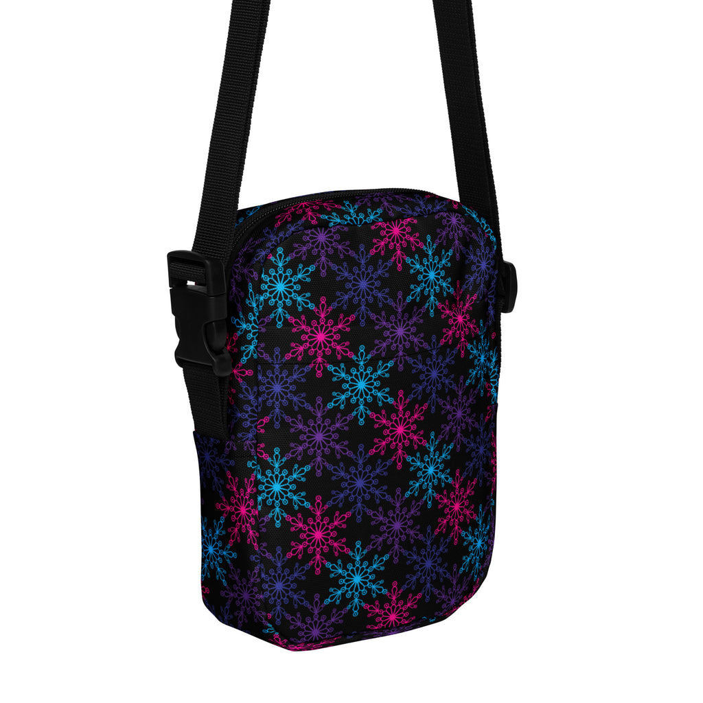 A black girls neon snowflakes crossbody purse with vibrant pink blue and purple snowflake pattern