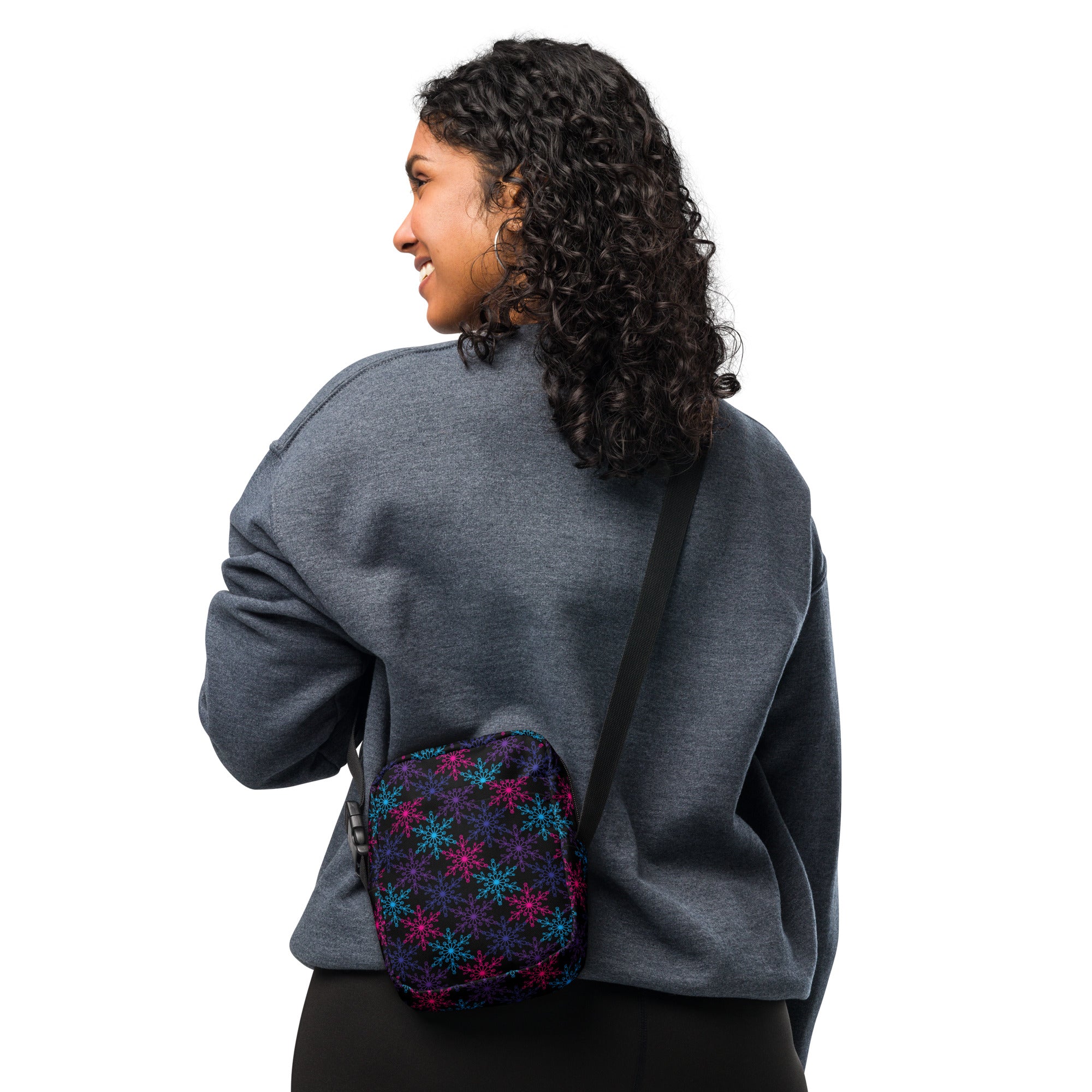 A small dark navy fabric crossbody bag with vibrant pink and blue neon snowflake patterns for winter use