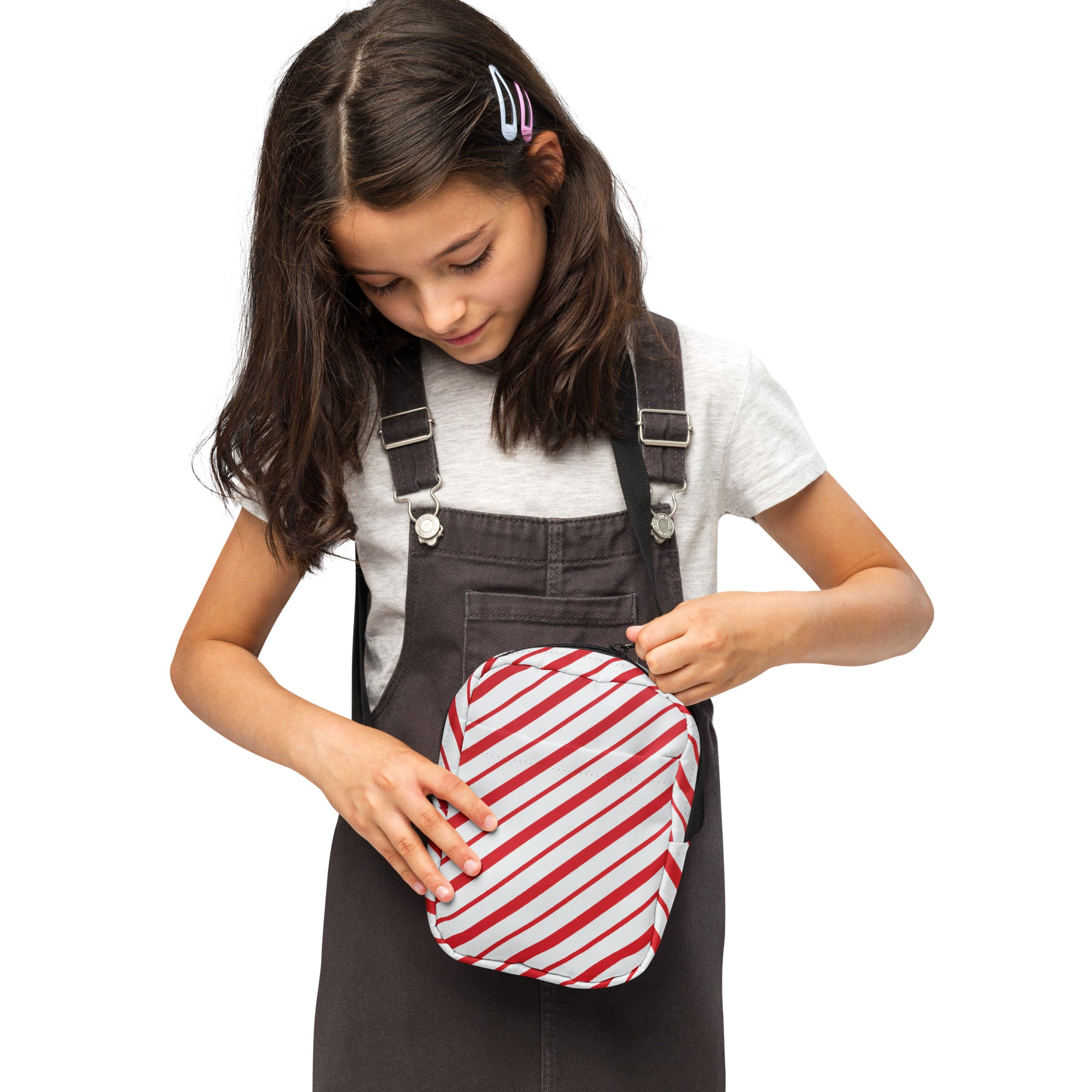Girls candy cane stripe christmas crossbody purse made of red and white diagonally striped fabric worn as a fanny pack