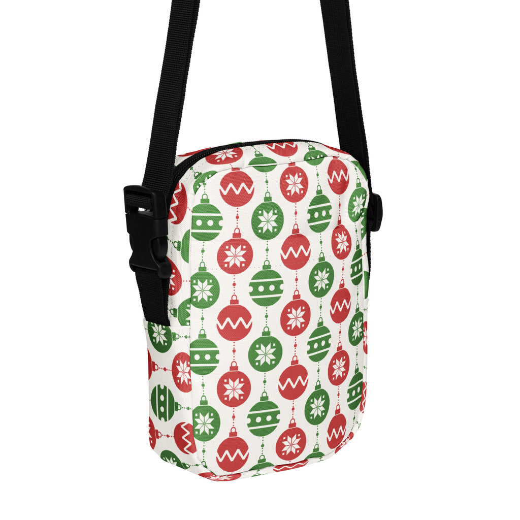 A festive Christmas ornaments women’s crossbody purse with red and green ornament pattern and black straps on white background