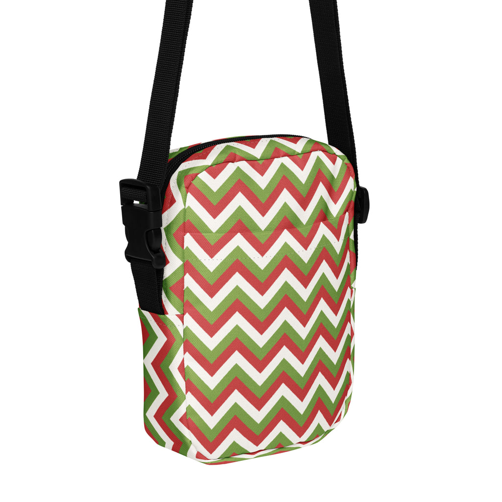 A girls christmas chevron crossbody purse with a bold red green and white zigzag fabric pattern