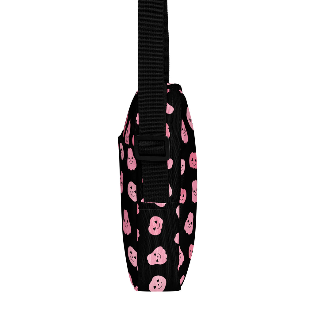 Black crossbody bag with pink smiling pumpkin faces and black adjustable strap for girls halloween use
