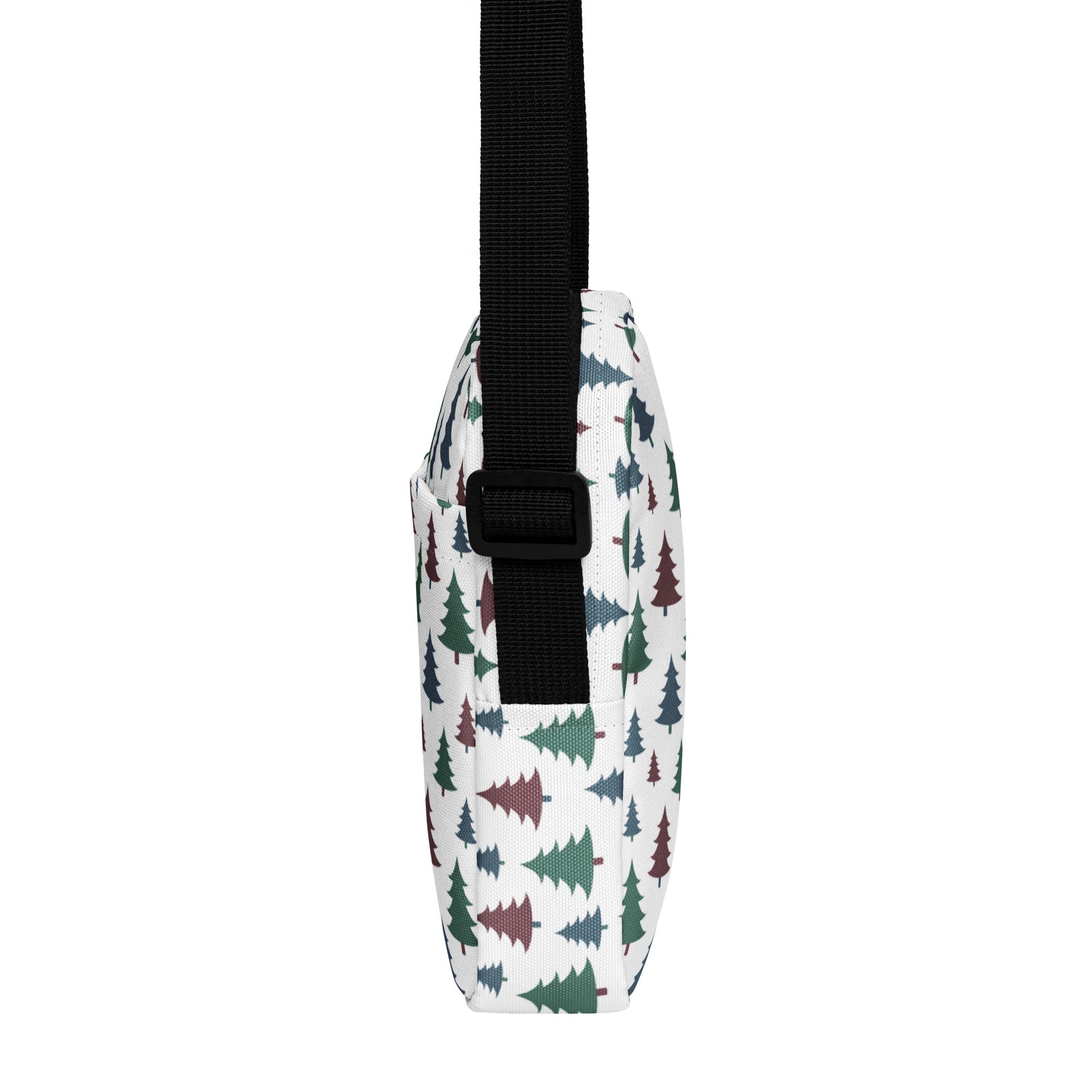 White crossbody purse with green and maroon pine tree pattern and black adjustable strap for winter and Christmas use