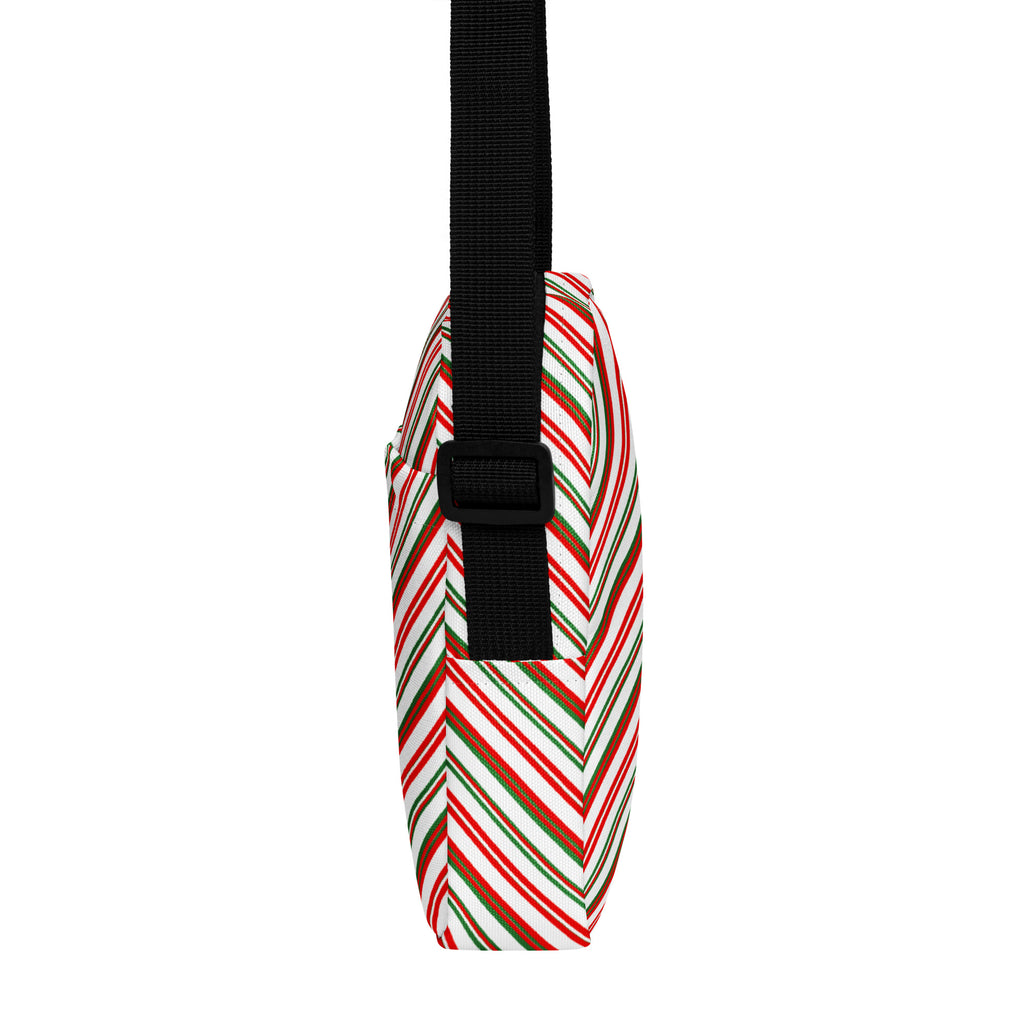 A festive multicolor diagonal candy stripe women’s crossbody purse with a candy cane pattern and black adjustable strap