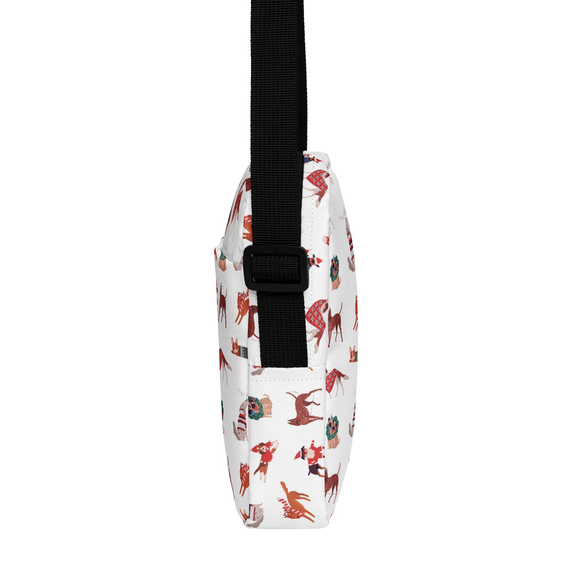 White crossbody bag with black strap featuring red brown and green holiday-themed dog illustrations
