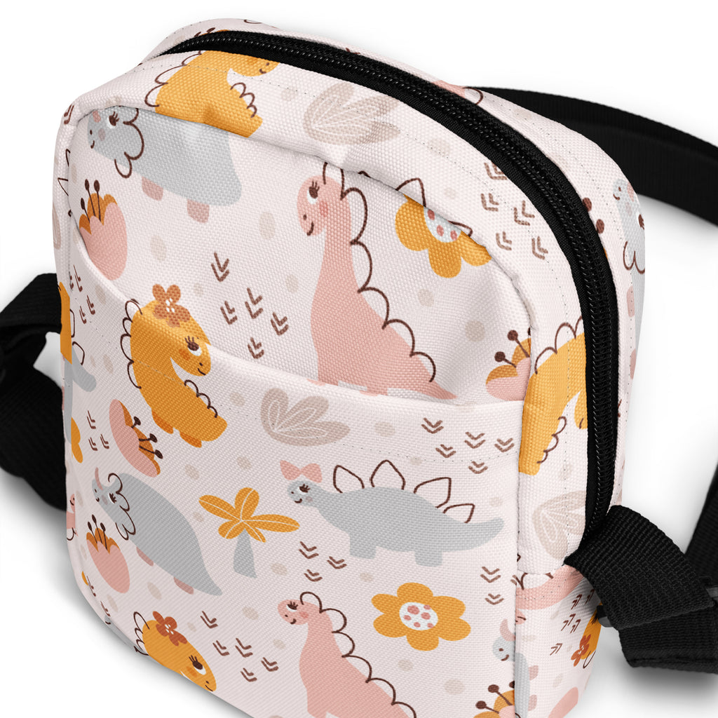 Girls floral dinosaur crossbody purse in white fabric with pastel cartoon dinosaurs flowers and black zipper trim
