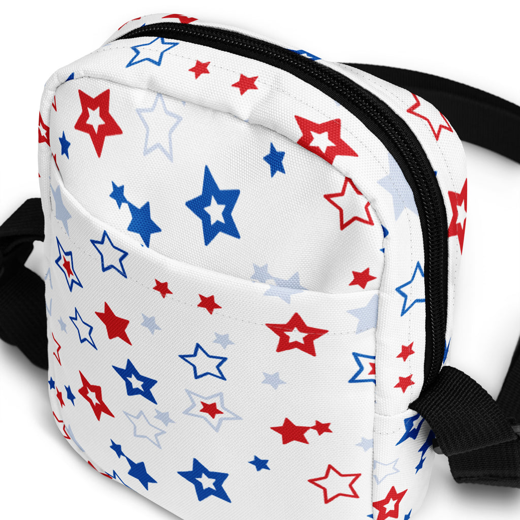Girls red white and blue stars crossbody purse with white fabric, colorful star pattern, black zipper trim, and adjustable strap