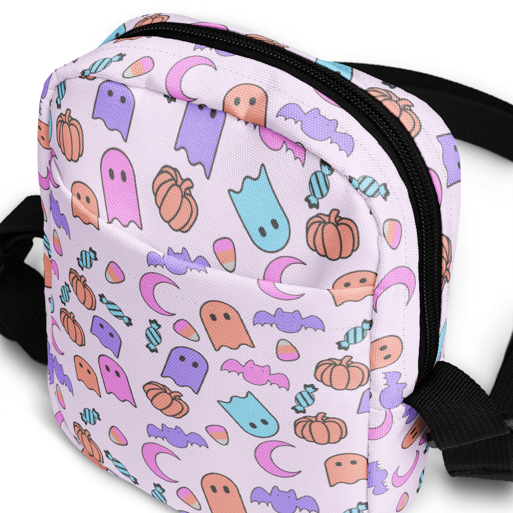 Girls ghost halloween crossbody purse in pastel colors with ghost pumpkin bat and candy motifs on light purple fabric