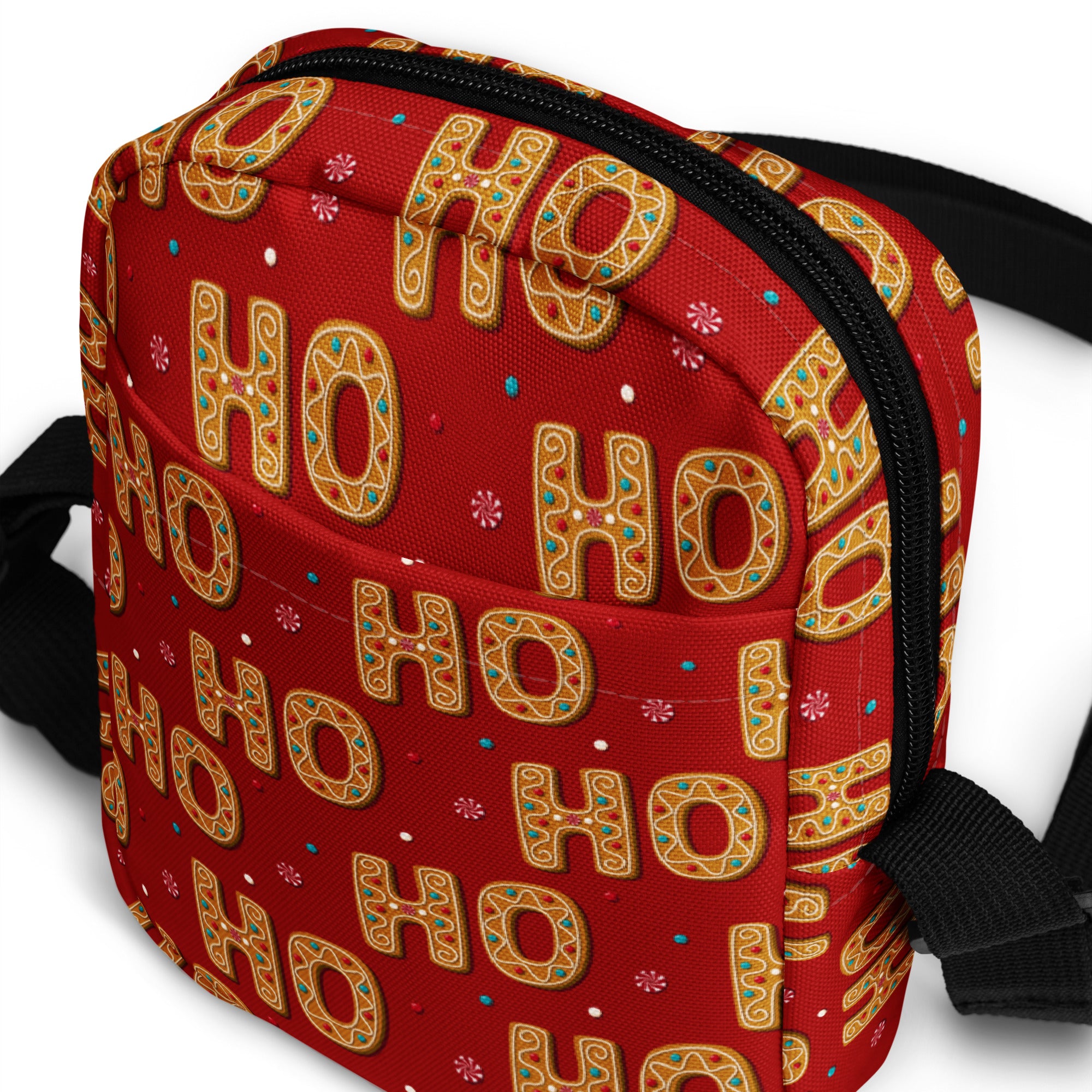 Red ’ho ho’ holiday-themed crossbody bag with gold gingerbread cookie design and black zipper.