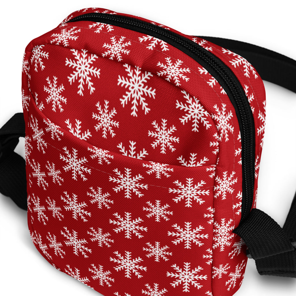 Red snowflake Christmas women’s crossbody purse with red fabric, white snowflake pattern, black zipper and strap