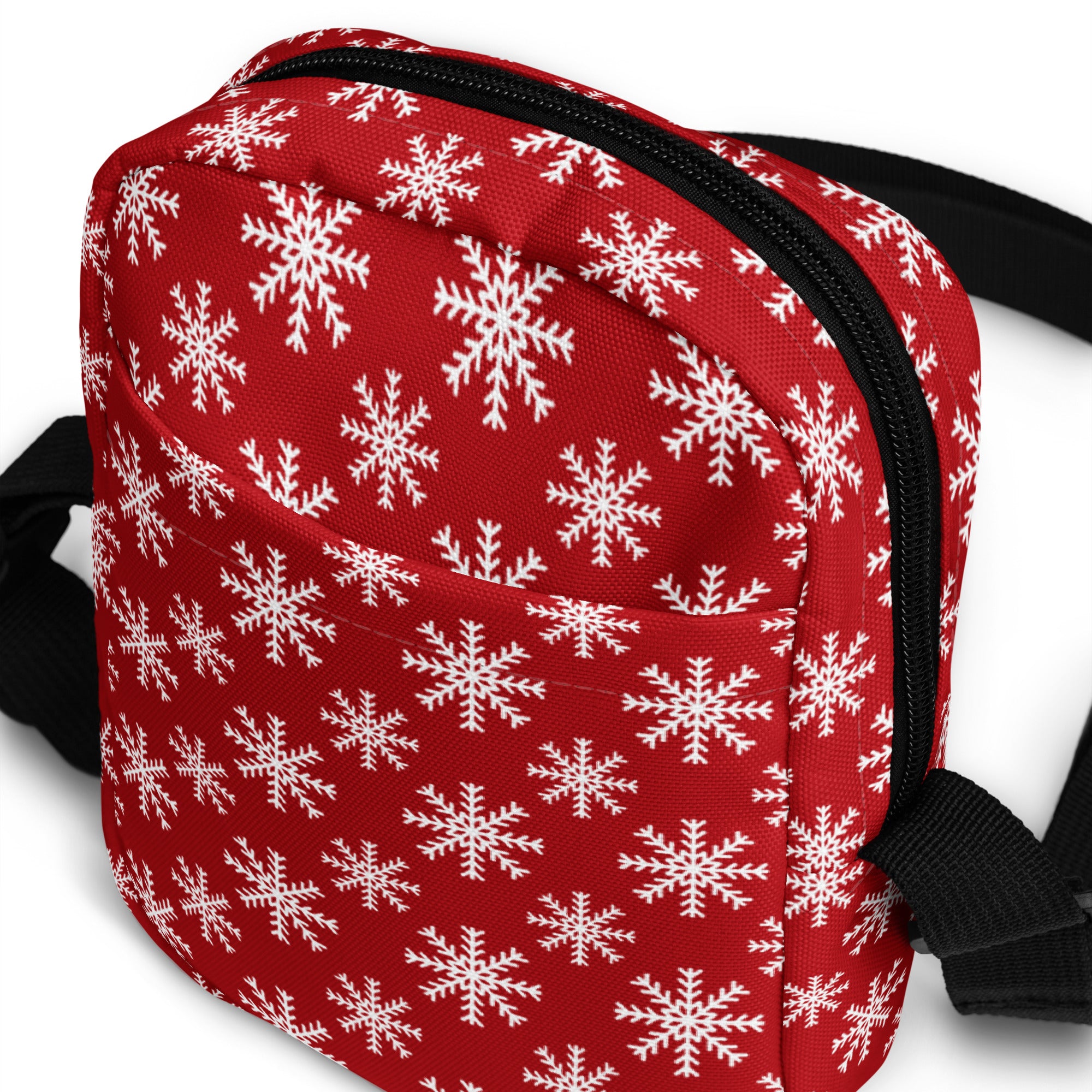 Red snowflake Christmas women’s crossbody purse with red fabric, white snowflake pattern, black zipper and strap