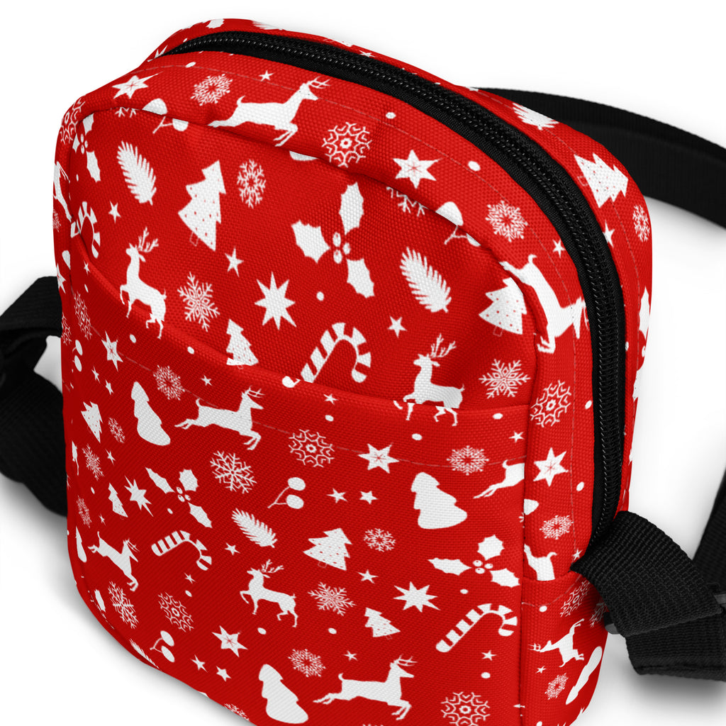 Girls red Christmas crossbody purse with white reindeer snowflakes candy canes and trees on fabric surface