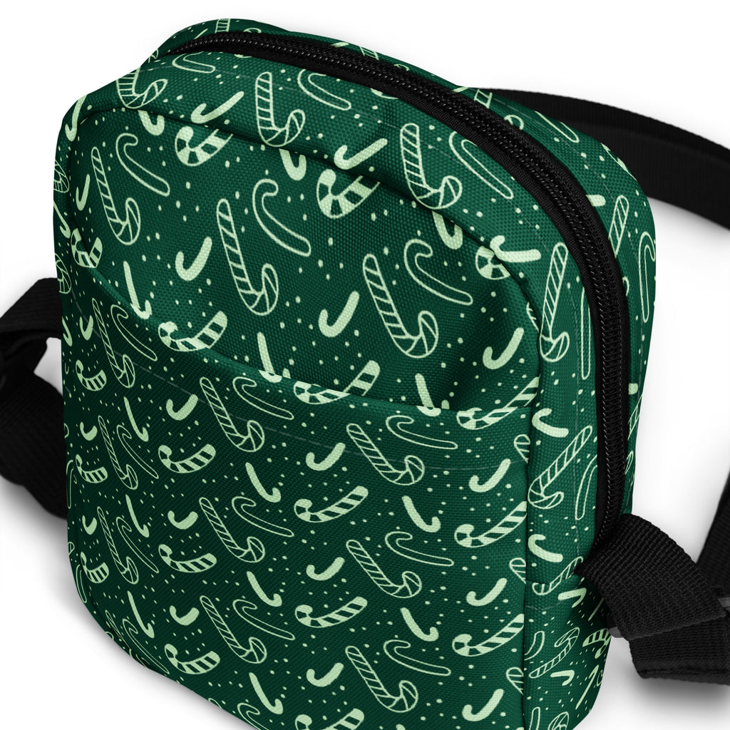 Girls green candy cane Christmas crossbody purse with playful white candy cane pattern and black zipper trim and straps