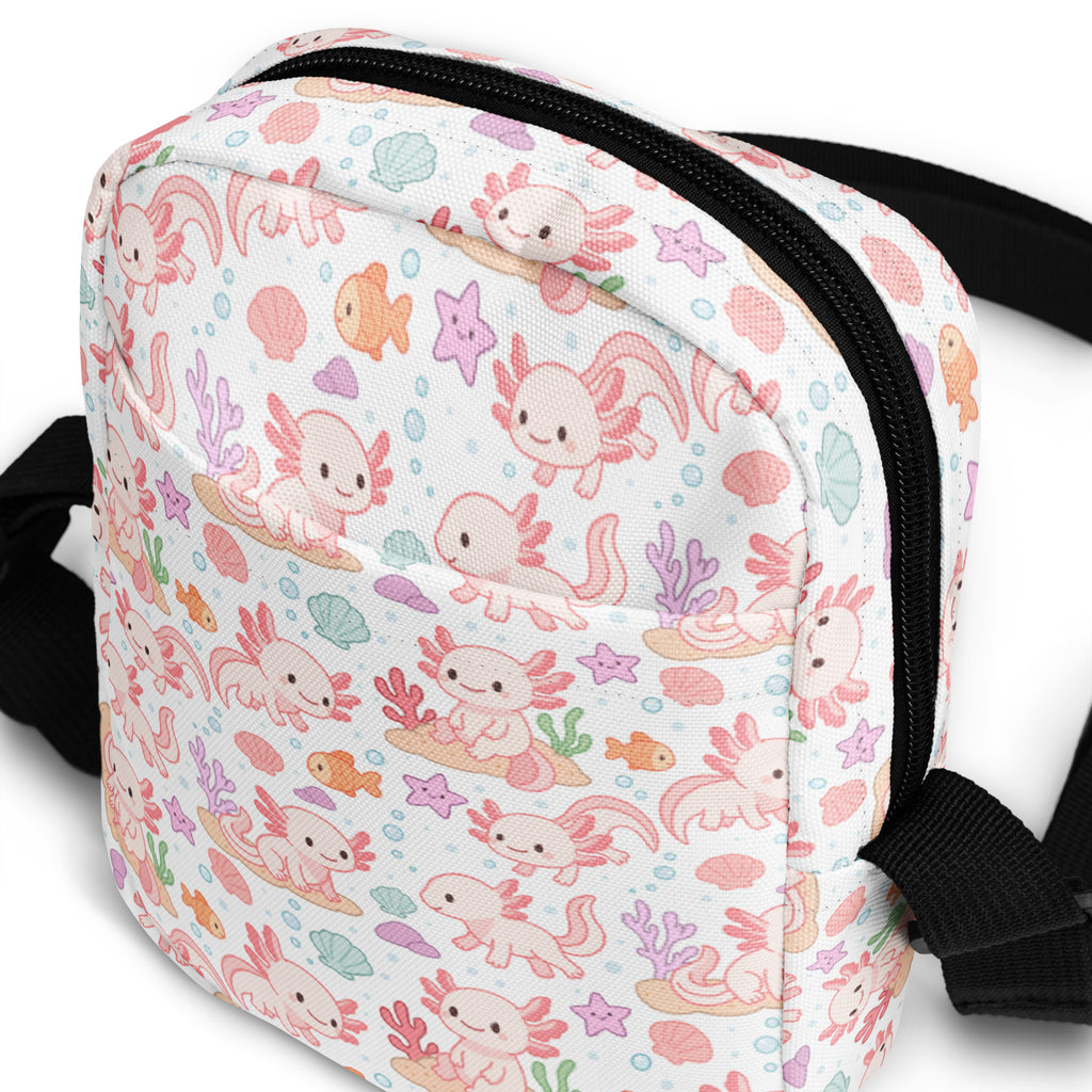 A white girls axolotl crossbody purse with pink axolotls orange fish and pastel sea creatures pattern