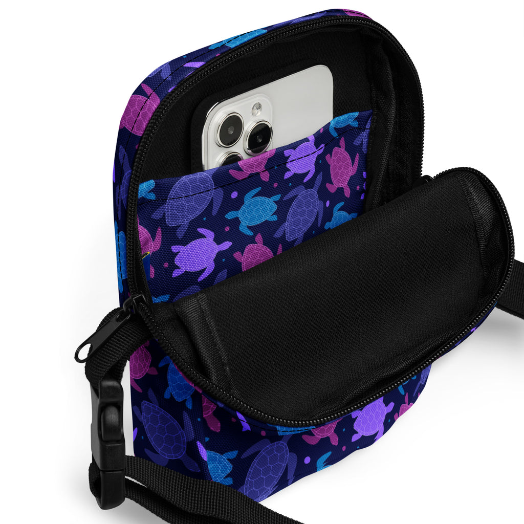 Girls purple sea turtle crossbody purse featuring a vibrant patterned phone pouch with black zipper and adjustable strap