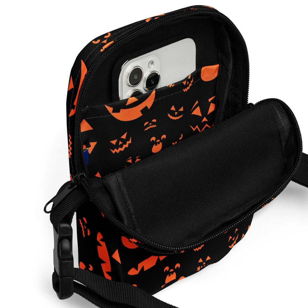 Girls black crossbody bag with orange jack-o-lantern face pattern for Halloween with adjustable strap