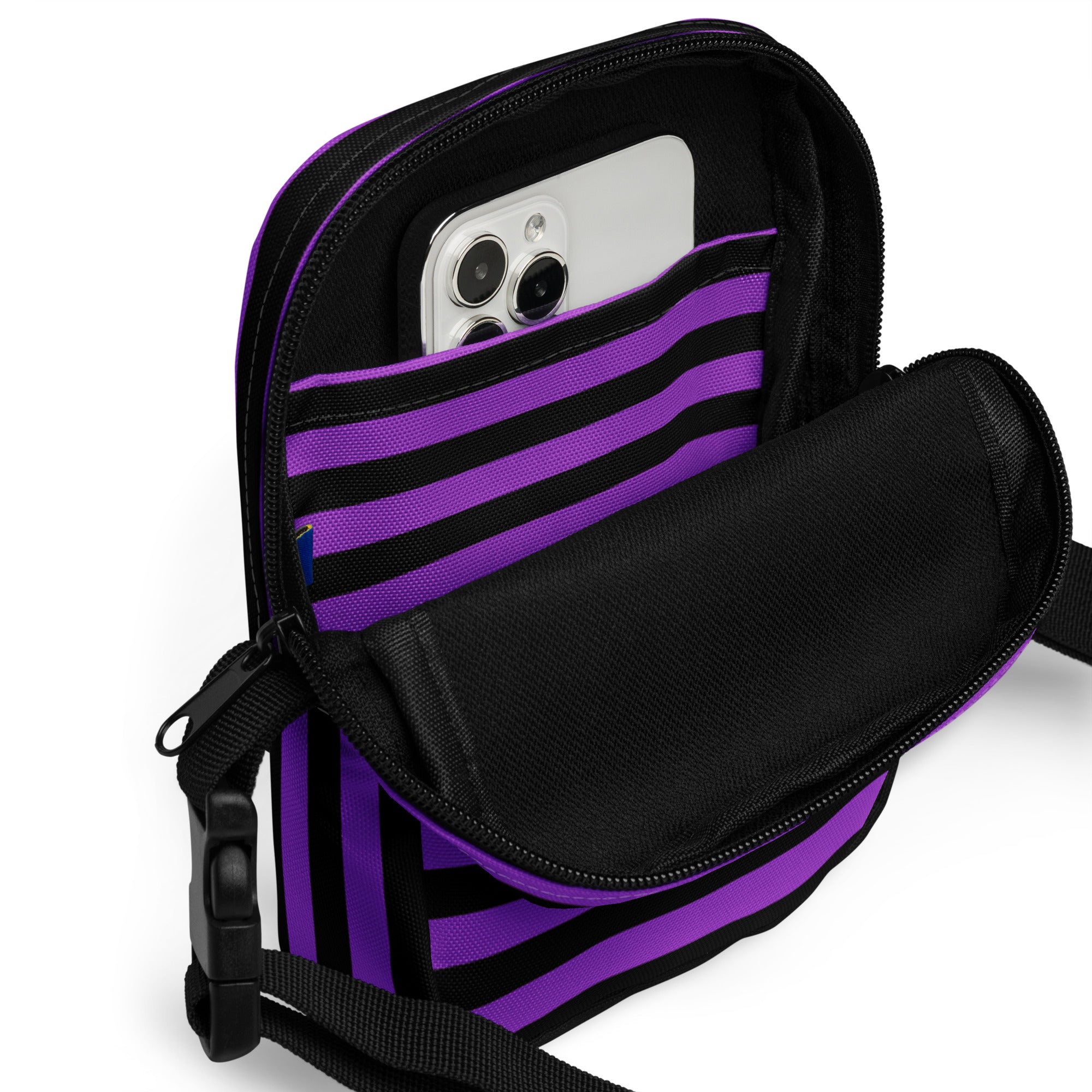 Girls purple and black striped Halloween crossbody purse with zippered compartment holding a smartphone