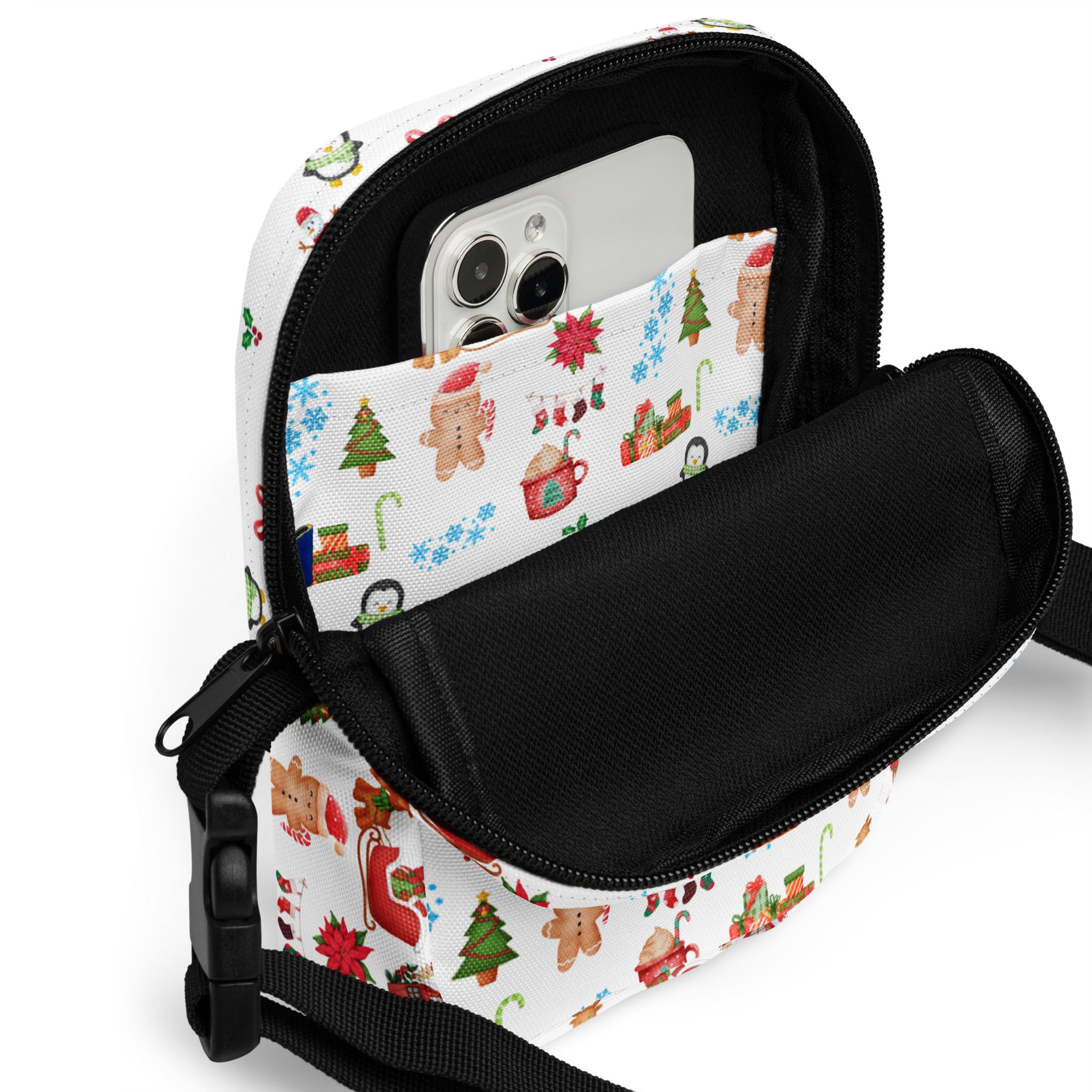 White christmas women’s crossbody purse with festive gingerbread men, trees, and penguins on fabric surface