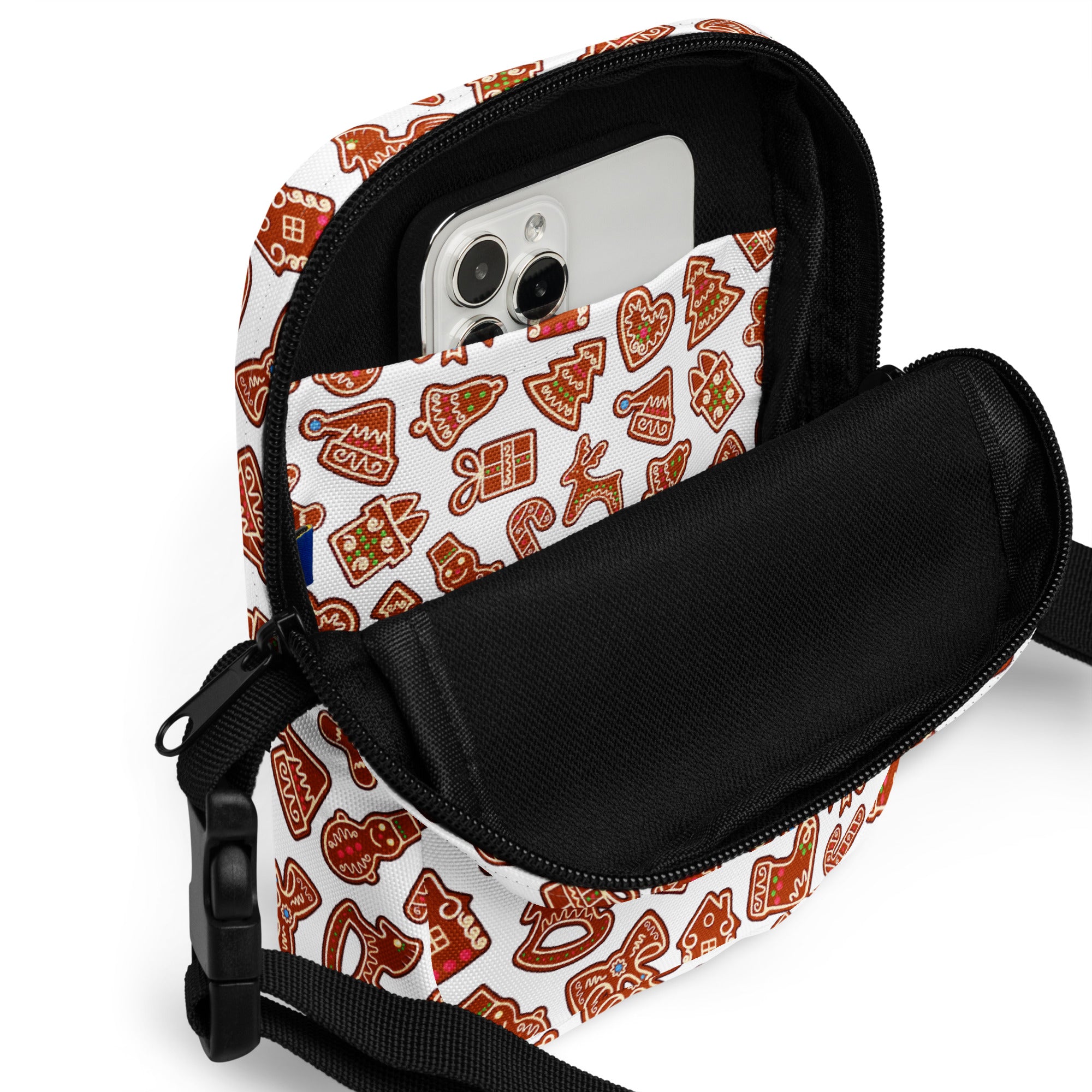 White crossbody bag with festive gingerbread cookie pattern in brown and red featuring black zippers and straps