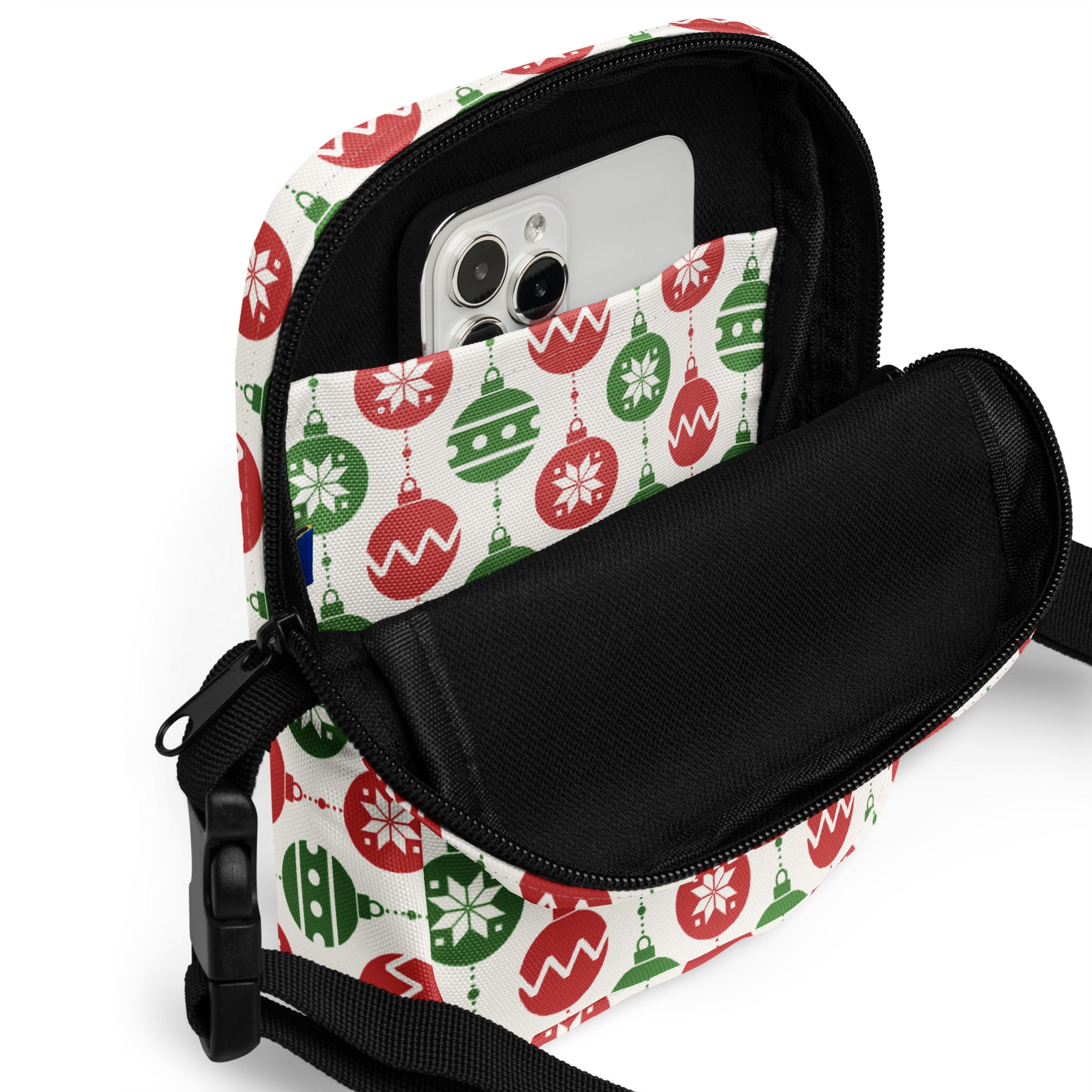 A festive white crossbody purse with red and green christmas ornaments and snowflakes lined with black fabric