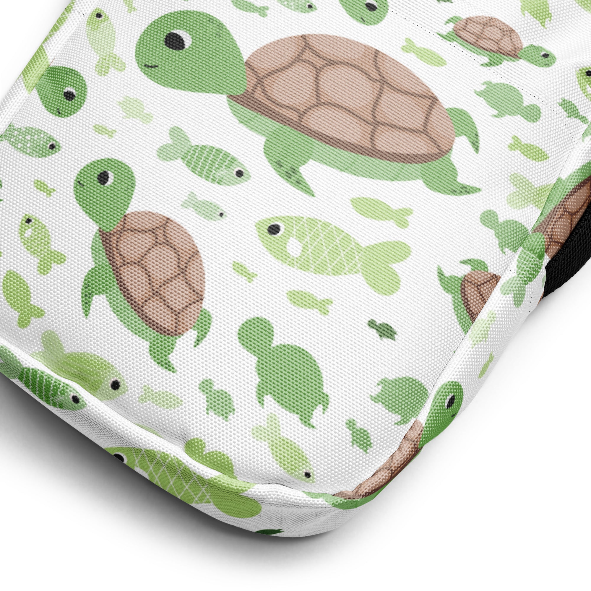 A white fabric girls crossbody purse with a playful green sea turtle and brown shelled fish pattern