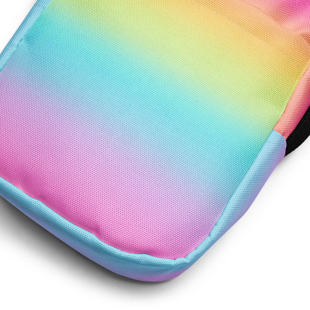 Girls bright rainbow crossbody purse with rainbow gradient canvas, stitched seams, and contrasting light blue trim