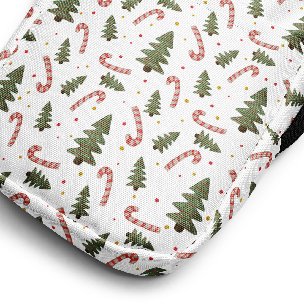 White fabric crossbody purse decorated with green pine trees and red and white striped candy canes for holiday use