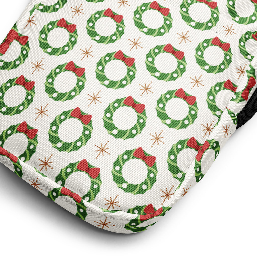 White fabric oven mitt with green wreaths red bows and gold starbursts featured in girls christmas wreath crossbody purse
