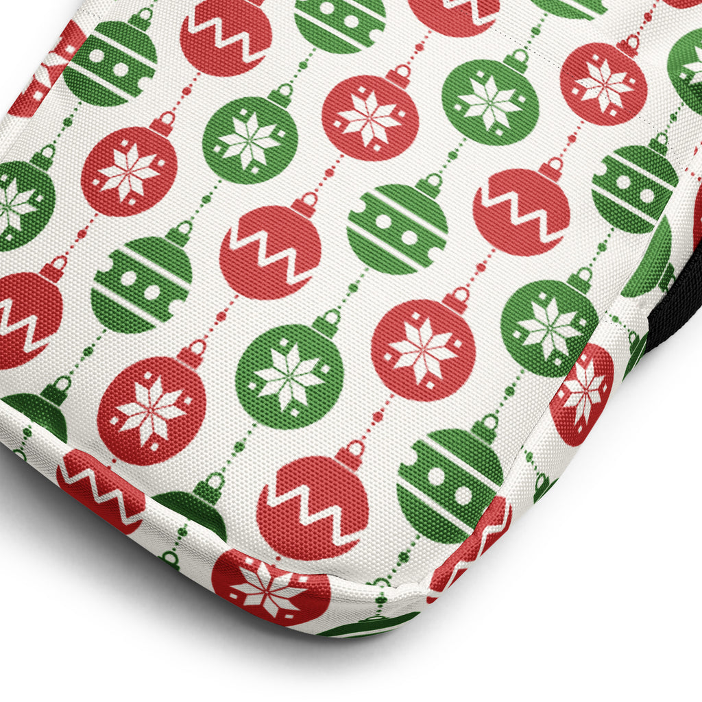 A festive white fabric women’s crossbody purse with red and green christmas ornament pattern and snowflake designs