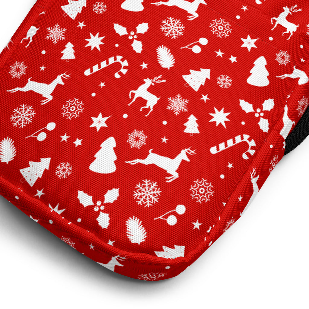 Girls red crossbody purse made of fabric with white christmas pattern featuring reindeer snowflakes trees and candy canes