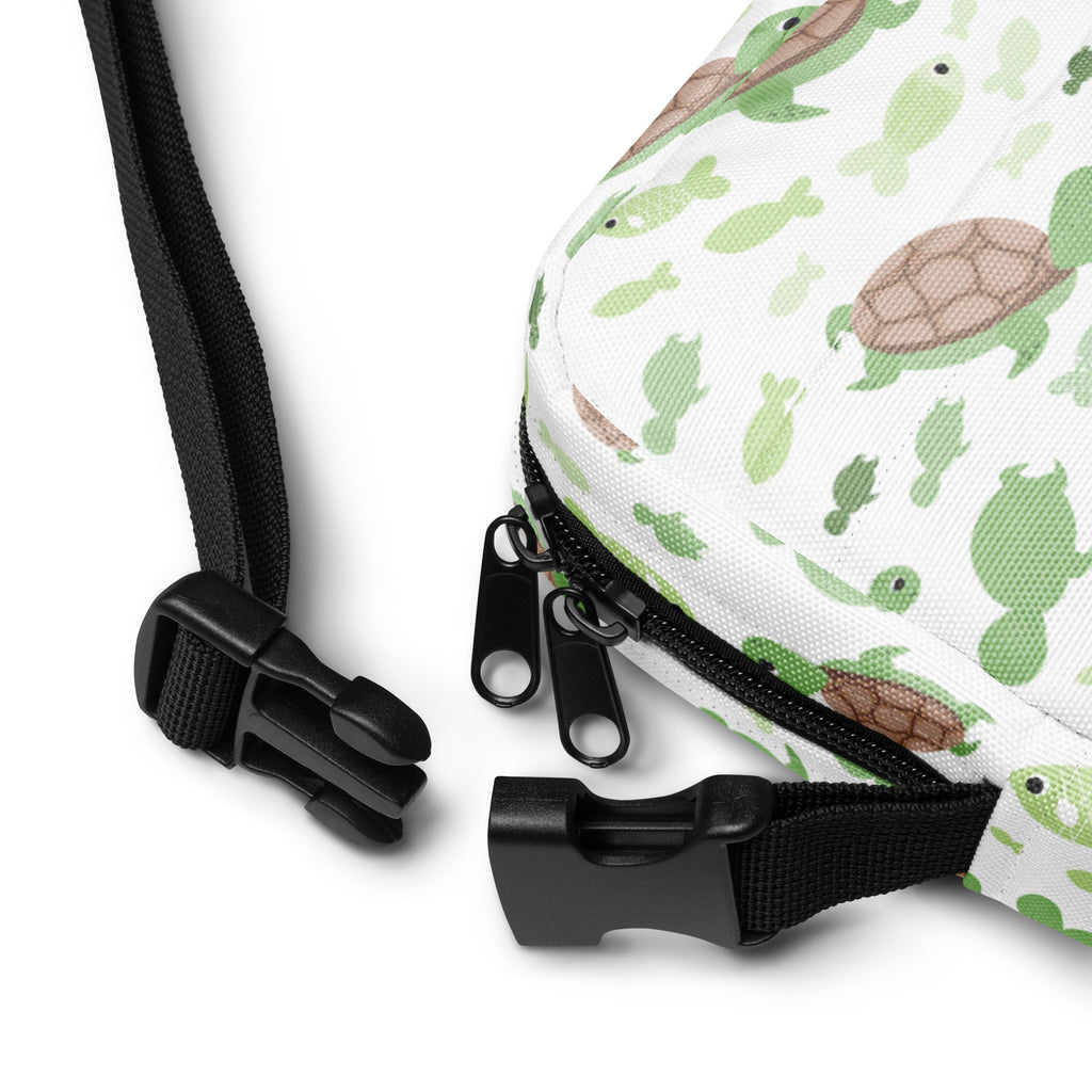 Girls green sea turtle crossbody purse in white with playful green and brown turtle and fish pattern black zippers and straps