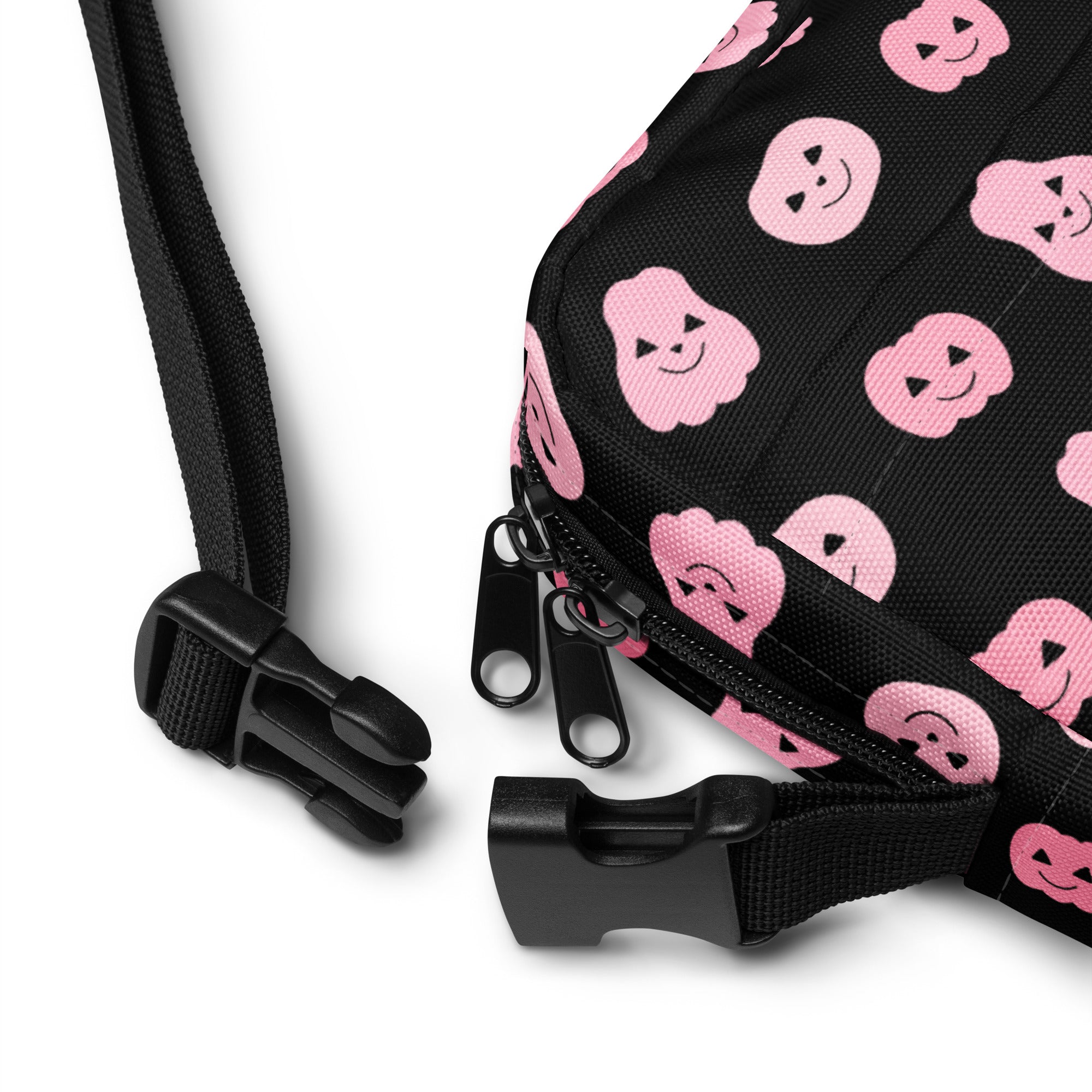 Black fabric girls crossbody bag with pink smiling pumpkin faces for halloween use
