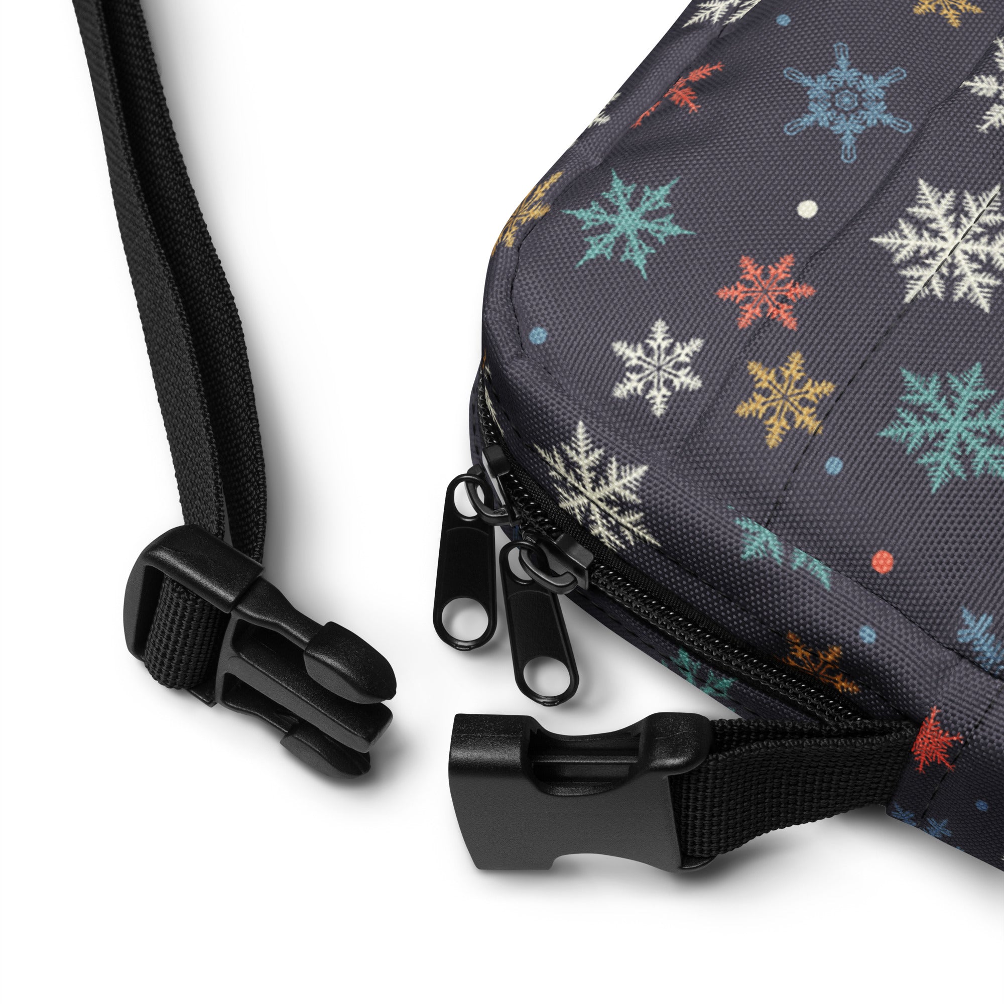 A dark gray fabric crossbody bag with colorful white blue orange and yellow snowflake pattern for women