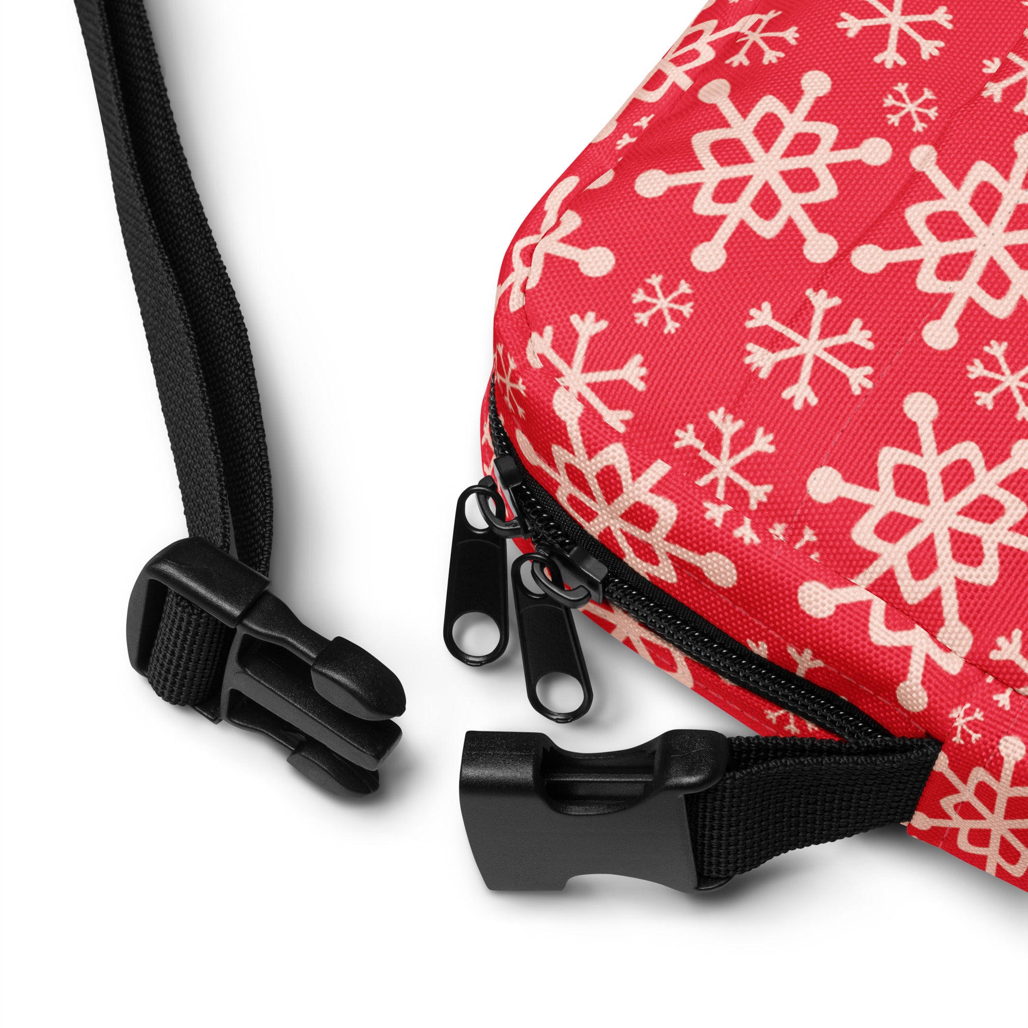 Girls red crossbody purse with white snowflake pattern on fabric and black zipper pulls