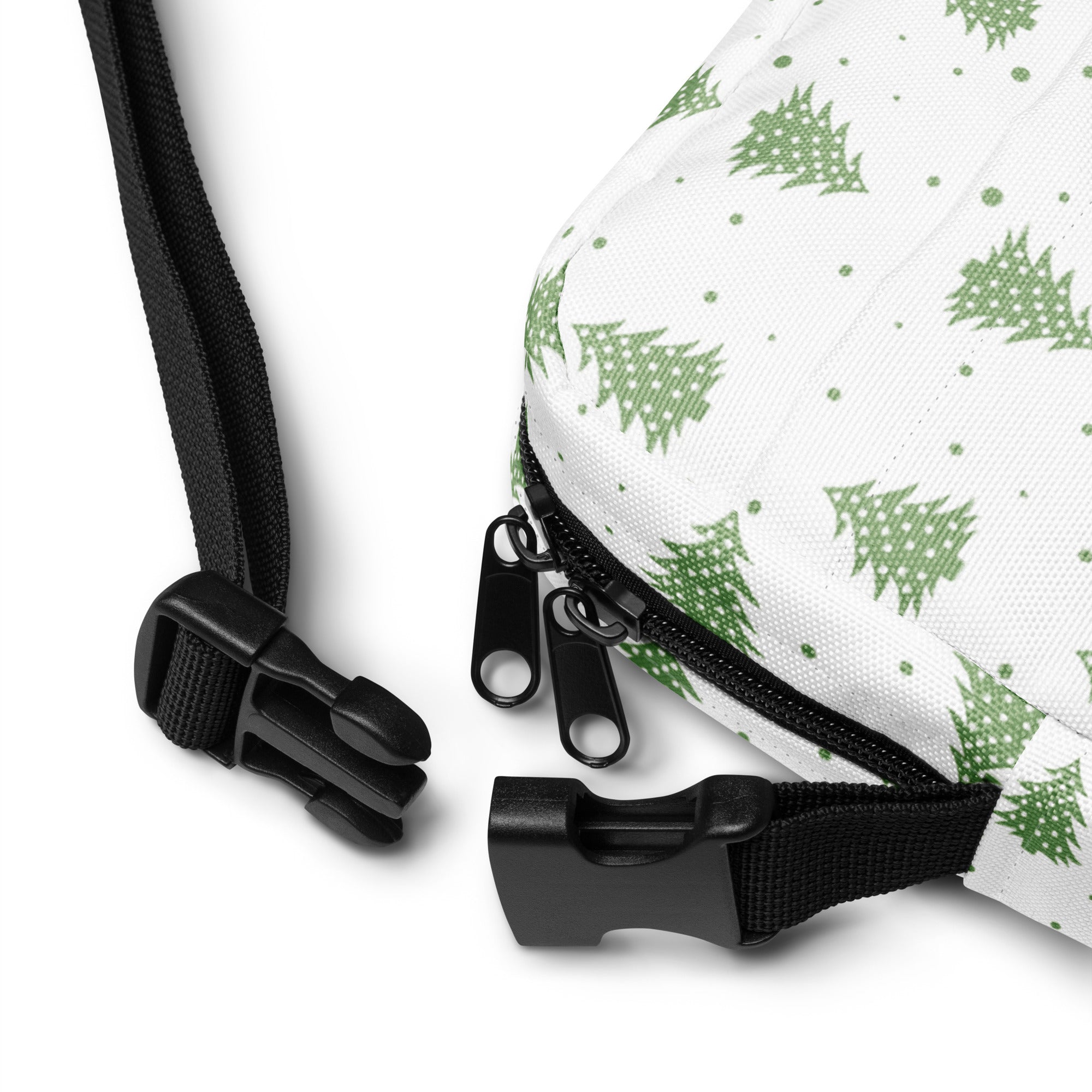 White crossbody bag with green pine tree pattern and black zipper pulls for christmas tree winter style
