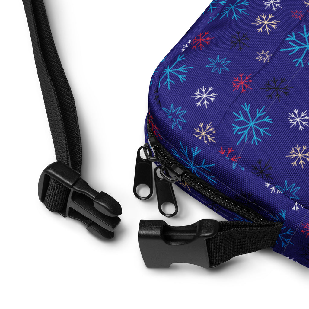 A vibrant blue fabric crossbody purse with multicolored snowflake pattern for Christmas winter use