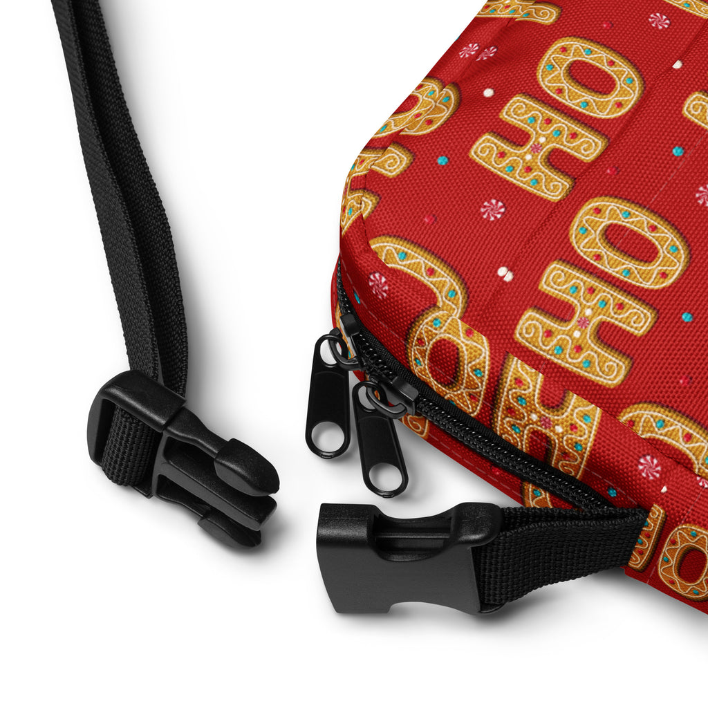 Red fabric crossbody bag with gold ho ho ho lettering and festive candy decorations for Christmas use