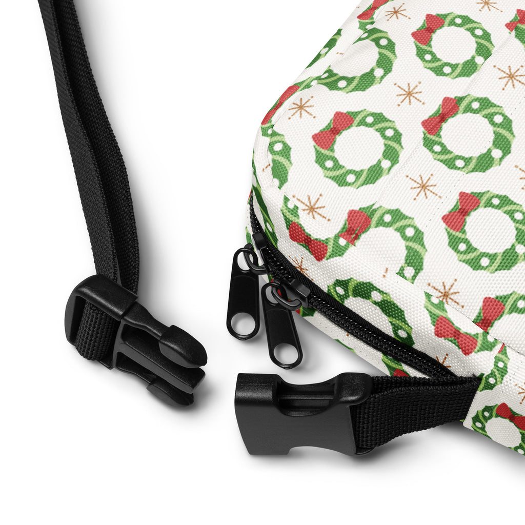 Girls christmas wreath crossbody purse featuring a white bag with green wreaths red bows and gold star accents