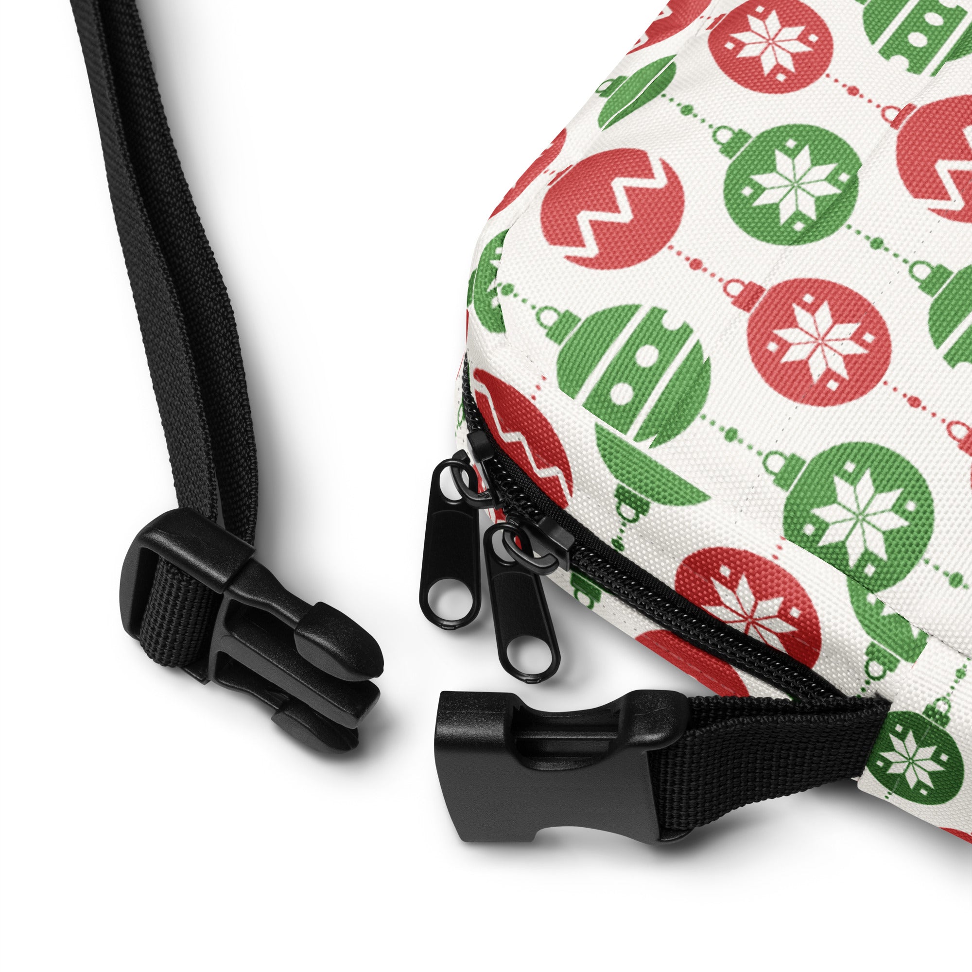 A festive white crossbody purse with red and green christmas ornament patterns and black adjustable straps